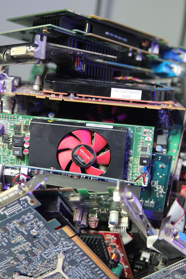 Stacked graphics cards and circuit boards on the bench at the Cyber Works shop