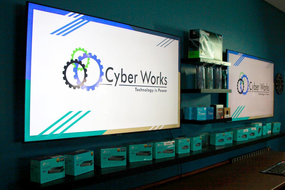 Two wall screens showing the Cyber Works logo inside the store on Willard Drive, Green Bay
